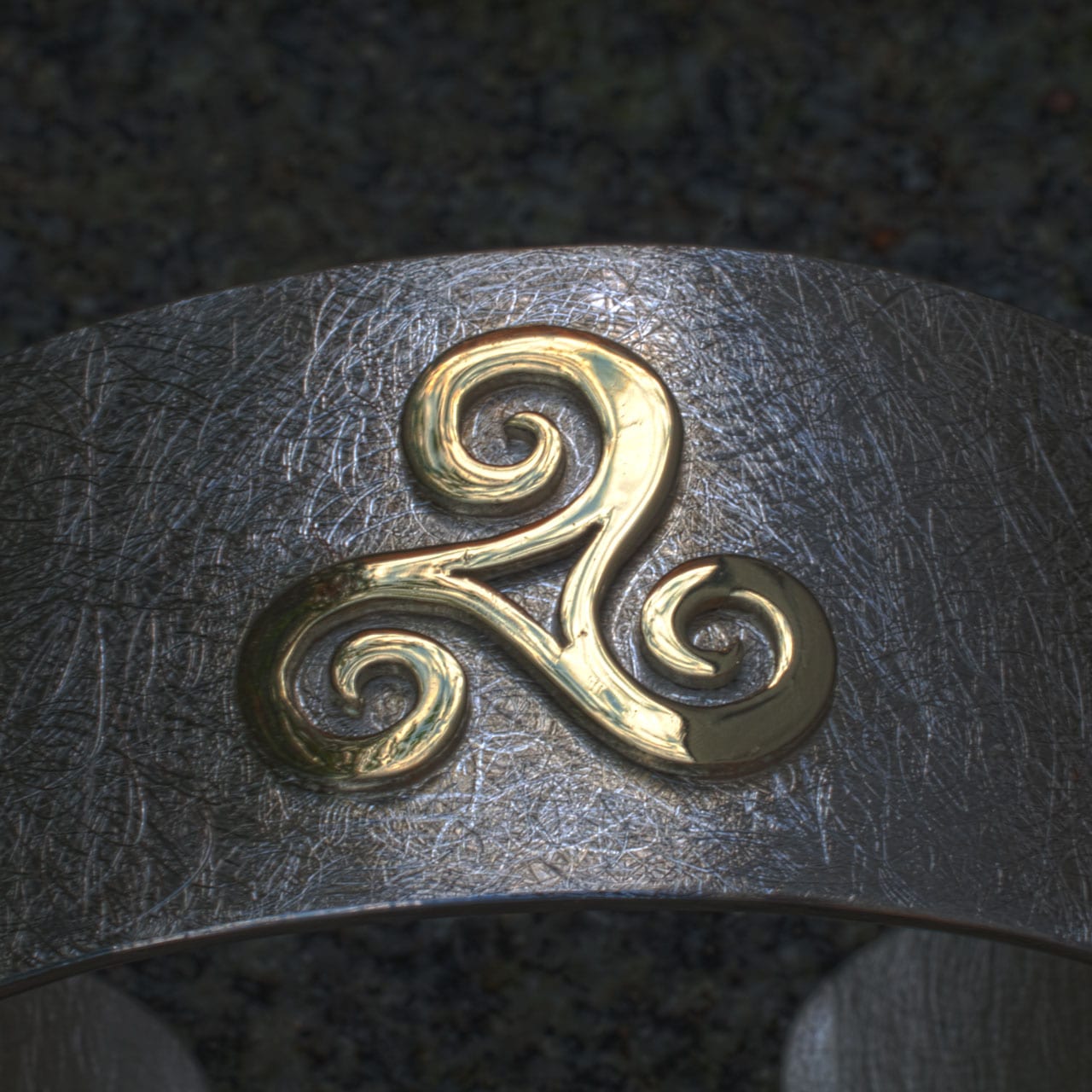 goldene Triscele auf Silberarmspange