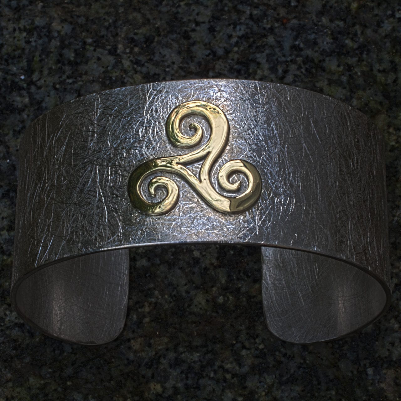 goldene Triscele auf Silberarmspange