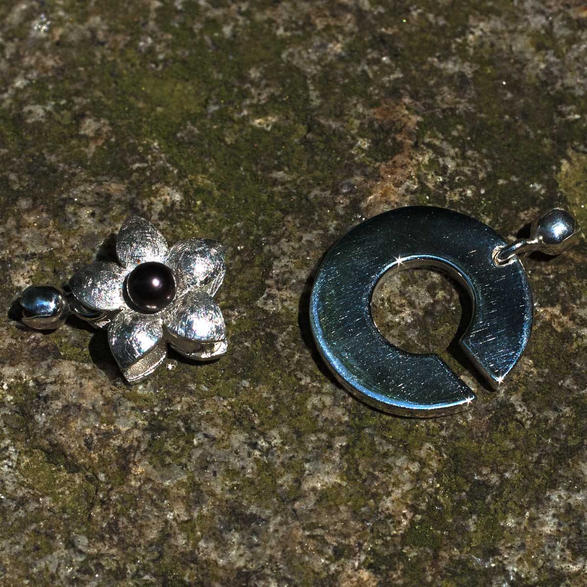 Schließe Blume mit schwarzer Perle