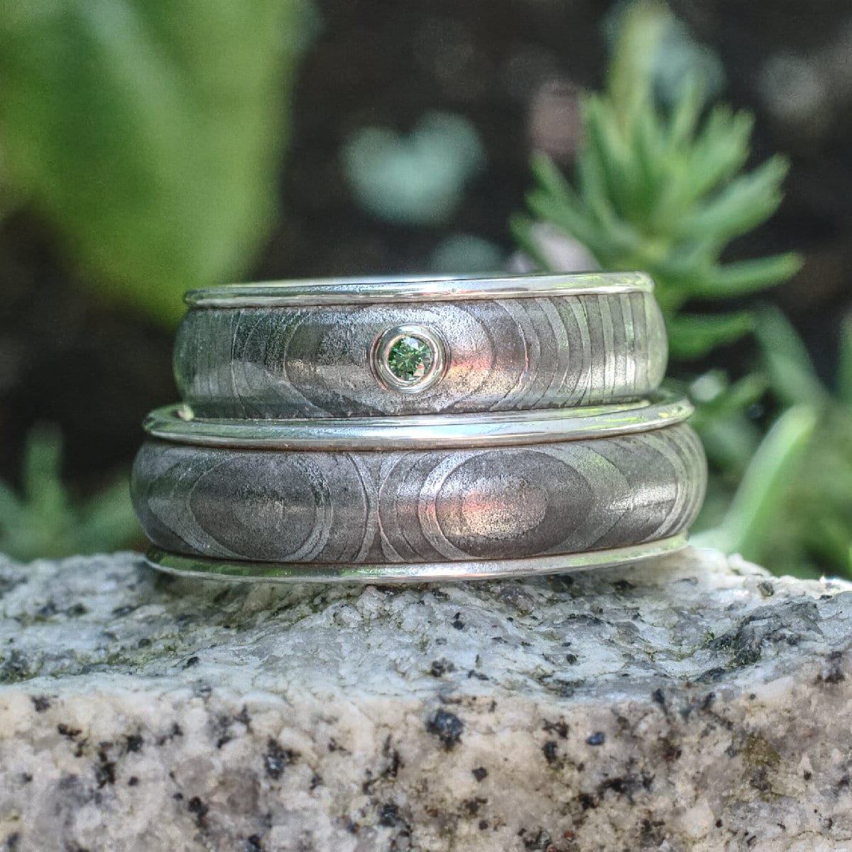 Damastringe mit Silberauskleidung und grünem Diamant im Damenring