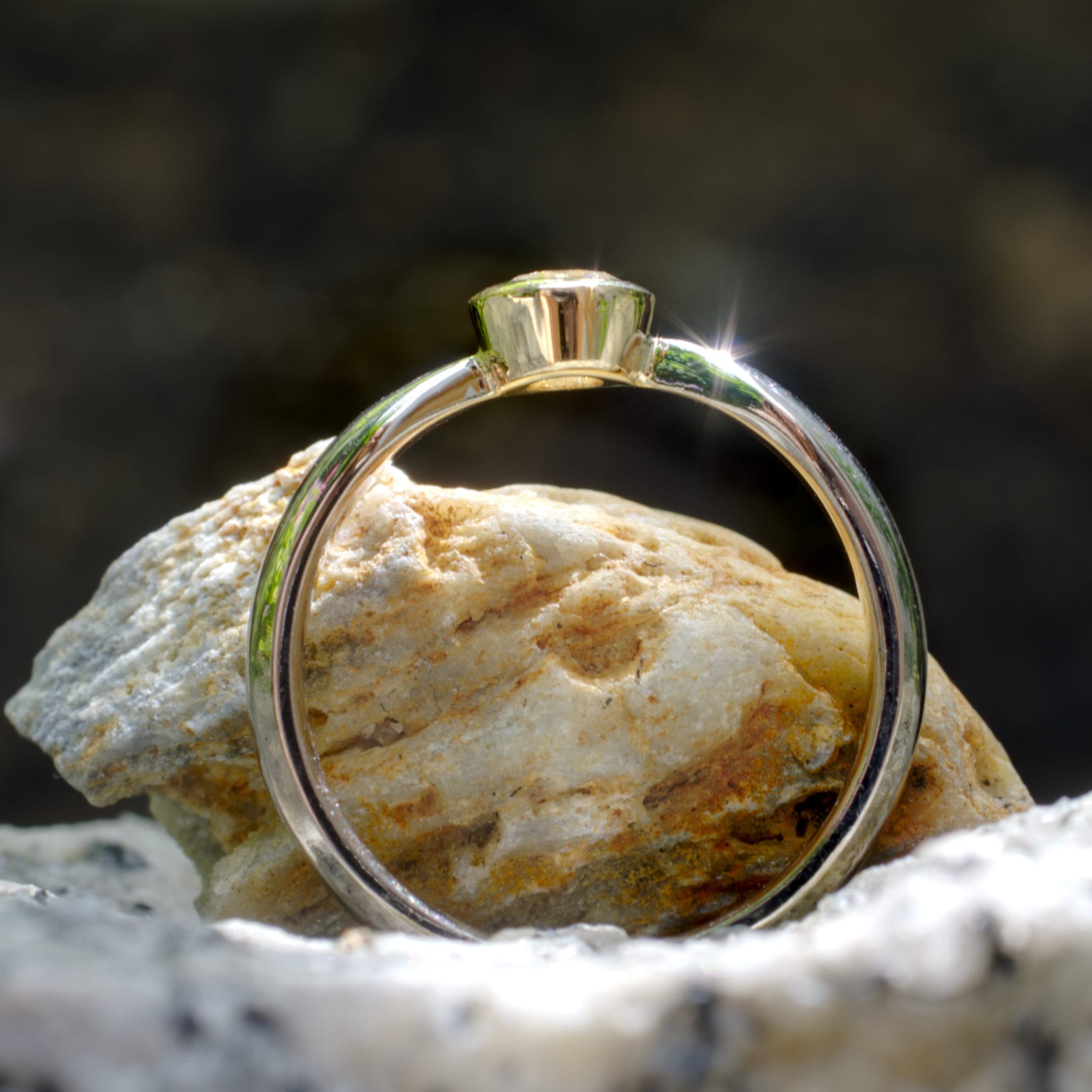 Brillant in konischer Gelbgold-Fassung in zur Fassung spitz zulaufender Weißgoldschiene